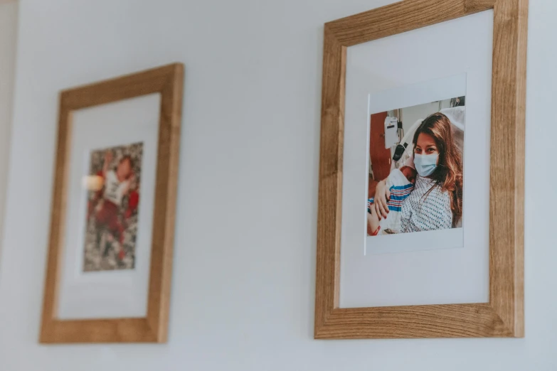 a couple of pictures hanging on a wall, by Emma Andijewska, pexels contest winner, head and shoulders in frame, local conspirologist, above the family room, photo shoot