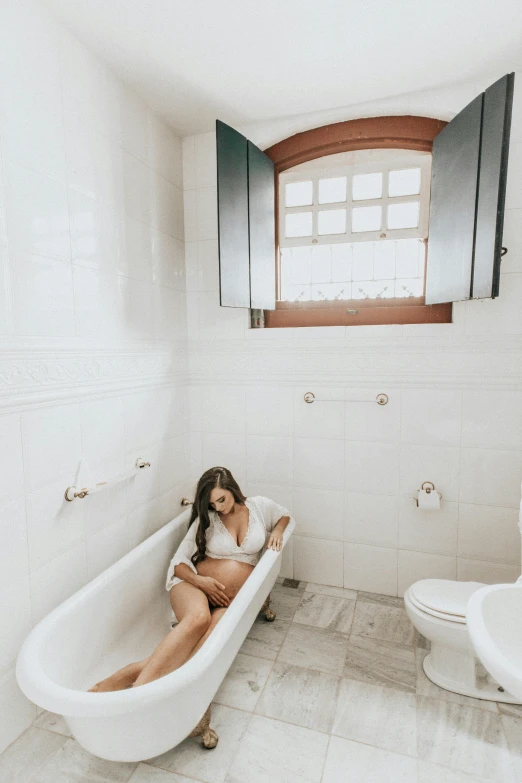 a woman sitting in a bathtub in a bathroom, by Nicolette Macnamara, trending on unsplash, renaissance, in sao paulo, in white room, maternity feeling, in chippendale sydney