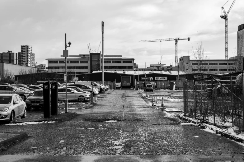 a black and white photo of a parking lot, inspired by Thomas Struth, unsplash, brutalism, coventry city centre, construction yard, post apocalyptic factory, photograph of april