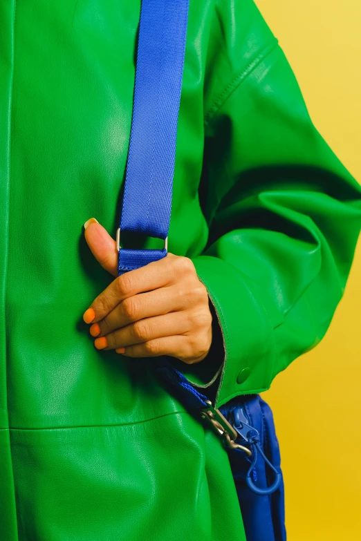 a close up of a person wearing a green jacket, an album cover, inspired by Hans Hofmann, trending on pexels, leather straps, brand colours are green and blue, dayglo, sustainable materials