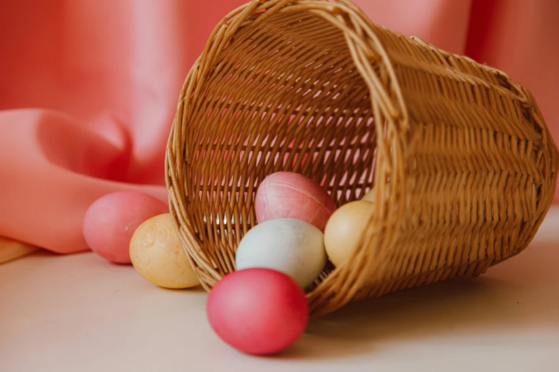 a basket filled with eggs sitting on top of a table, pink and red colors, unsplash contest winning photo, modelling clay, spheres