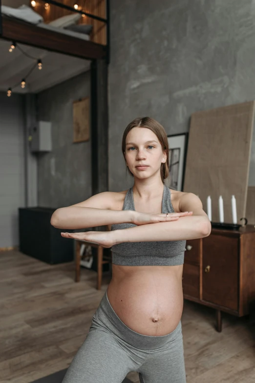 a pregnant woman standing in a yoga pose, by Adam Marczyński, pexels contest winner, renaissance, pretty face with arms and legs, gif, low quality photo, indoor picture