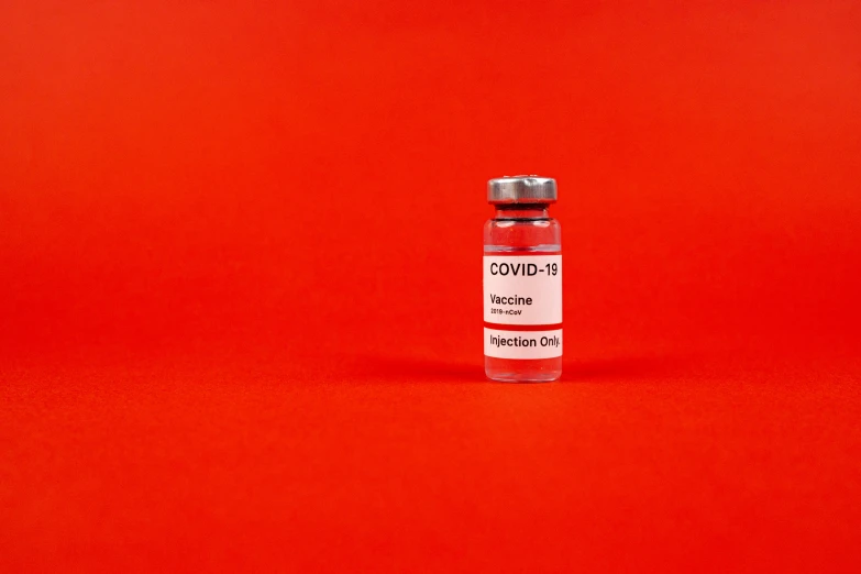 a bottle of blood sitting on a red surface, a picture, visual art, covid, steroid use, syringe, press release