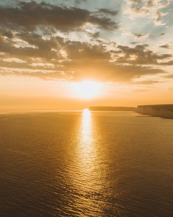the sun is setting over a body of water, pexels contest winner, romanticism, croatian coastline, golden hues, flying over the horizon, high quality image”