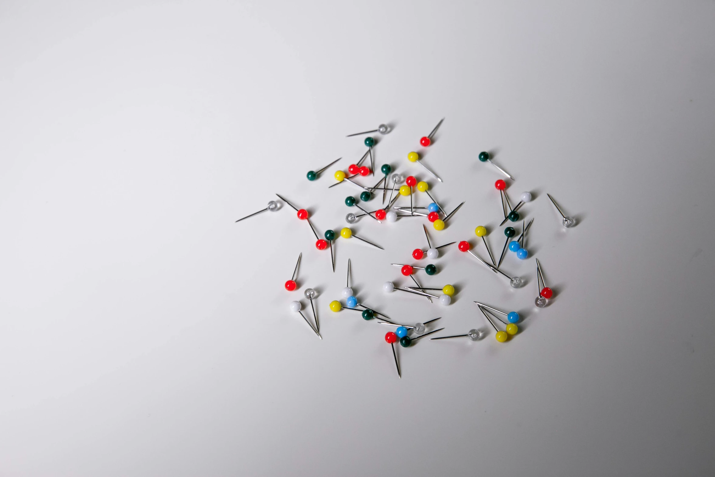 a bunch of pins sitting on top of a white surface, pexels, particle simulation, coloured, business, surgical supplies