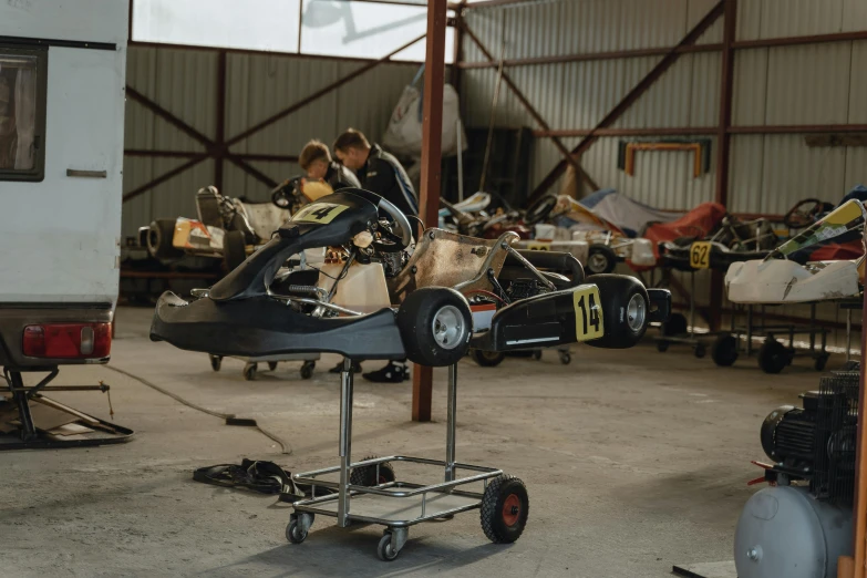 a group of people working on a car in a garage, a portrait, by Thomas Furlong, unsplash, bumper cars, f 1.4 kodak portra, on a racetrack, lachlan bailey
