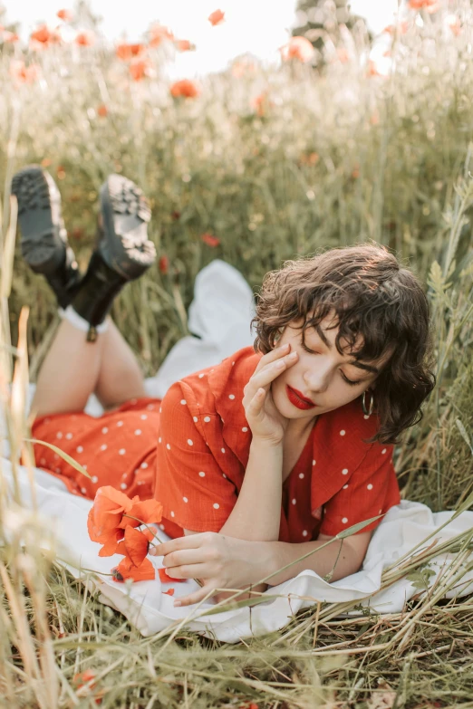 a woman laying on a blanket in a field of poppies, an album cover, by Julia Pishtar, curly bangs, wearing a red outfit, thoughtful ), polka dot