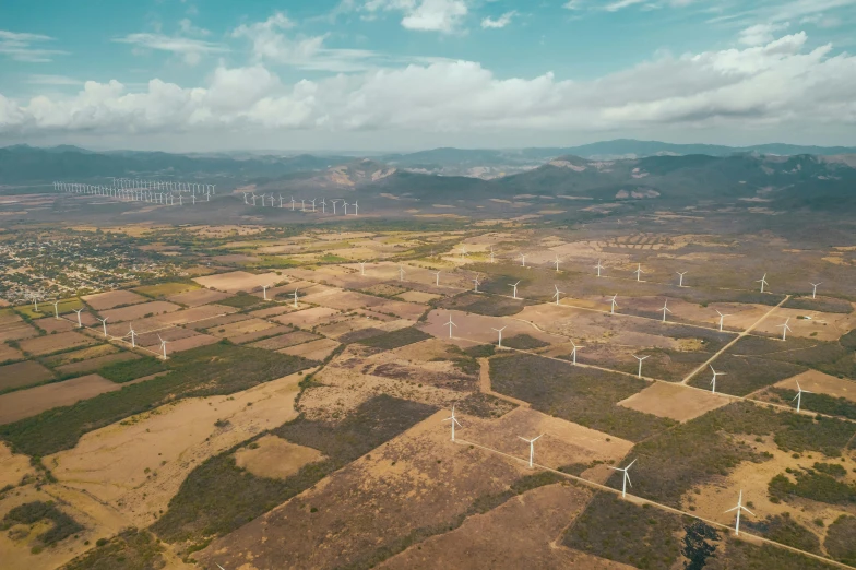 an aerial view of a wind farm, by Alejandro Obregón, pexels contest winner, wide view of a farm, cgi 8k, colombian, thumbnail