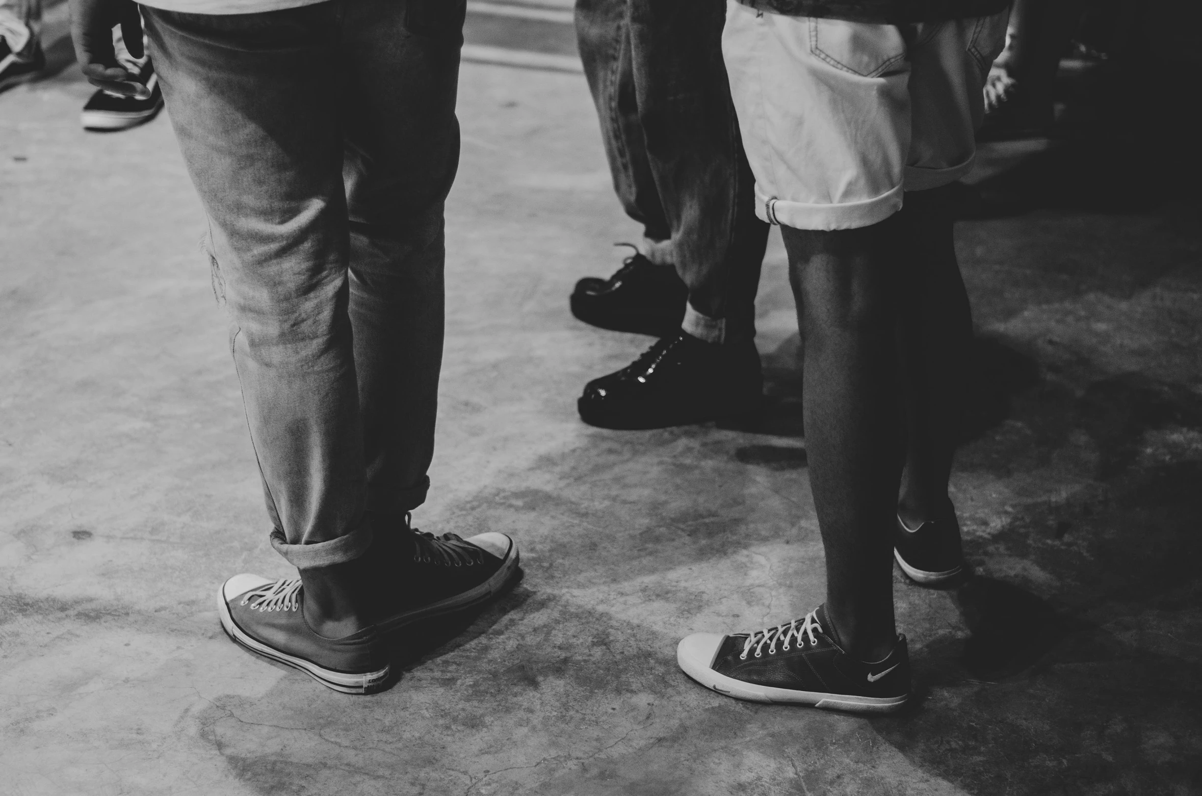 a couple of people standing next to each other, a black and white photo, by Matija Jama, pexels, visual art, sneaker shoes, line dancing at a party, teenage boy, dark-skinned