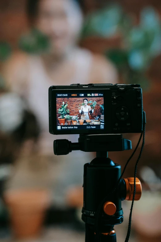 a cell phone sitting on top of a tripod, a picture, pexels contest winner, video art, lcd screen, indoor shot, sony alpha a6400, looking at camera