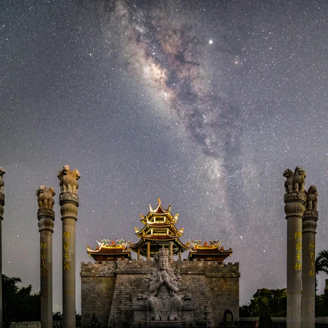 a group of pillars in front of a building with a sky full of stars in the background, by Reuben Tam, with a chinese temple, arching milkyway, square, hyperdetailed photograph