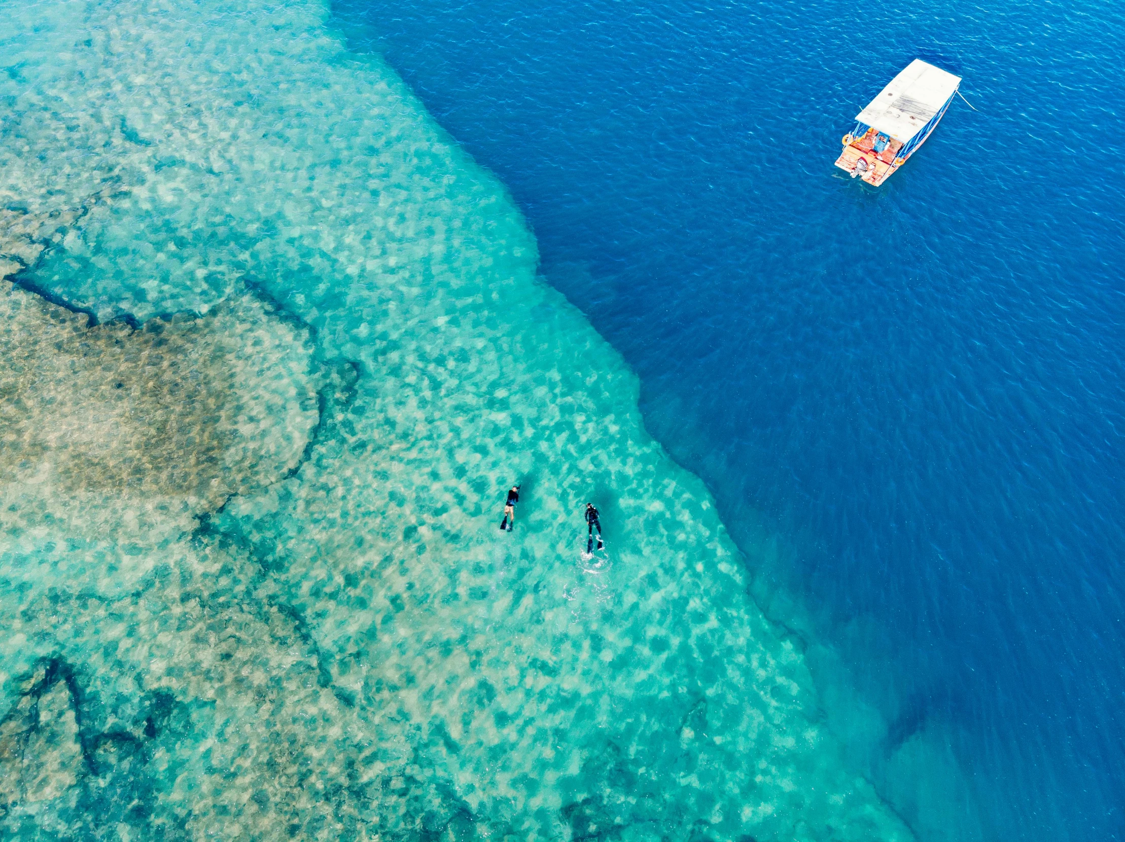 a couple of boats floating on top of a body of water, a screenshot, pexels contest winner, hurufiyya, coral sea bottom, australian beach, thumbnail, high angle shot