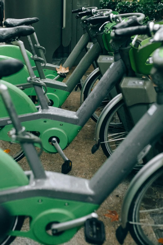 a row of green bicycles parked next to each other, by Sven Erixson, unsplash, happening, spinning, underground, 🚿🗝📝