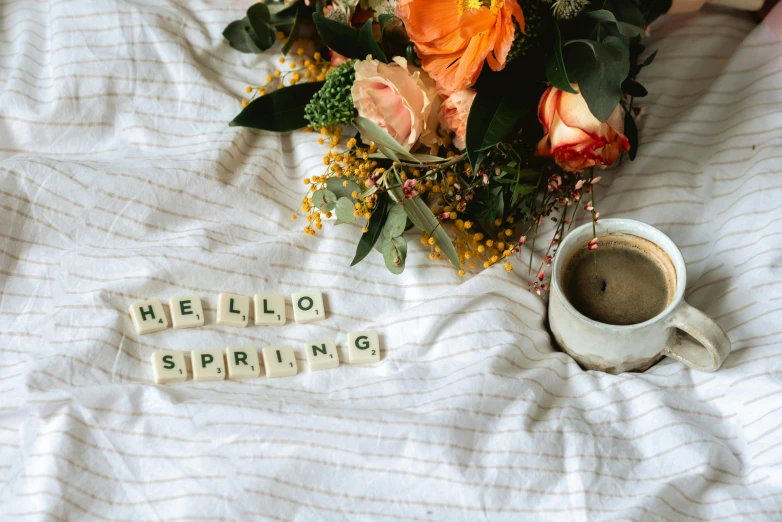 a bouquet of flowers sitting on top of a bed next to a cup of coffee, 3 are spring, hello, clothes made out of flower, thumbnail