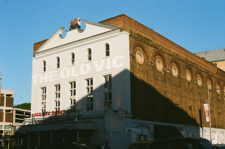 a large white building sitting on the side of a road, a photo, unsplash, art nouveau, theatre stage, sunfaded, victorian london, helio oiticica