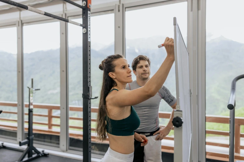 a woman standing next to a man in a gym, a picture, by Emma Andijewska, pexels contest winner, mountains in the background, background image, orazio gentileschi style, white