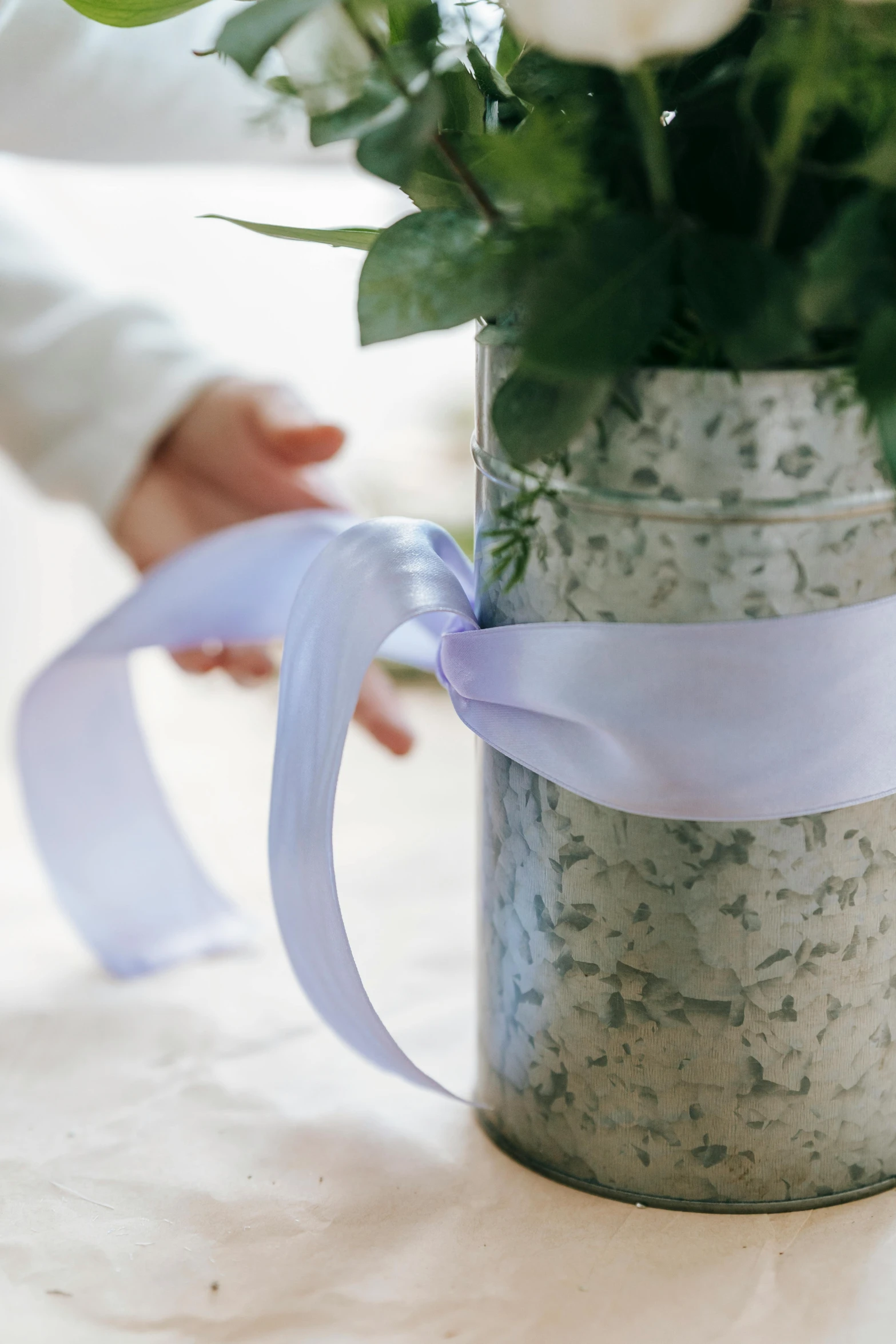 a close up of a vase with flowers in it, big ribbon, soft cool colors, with a sleek spoiler, subtle purple accents