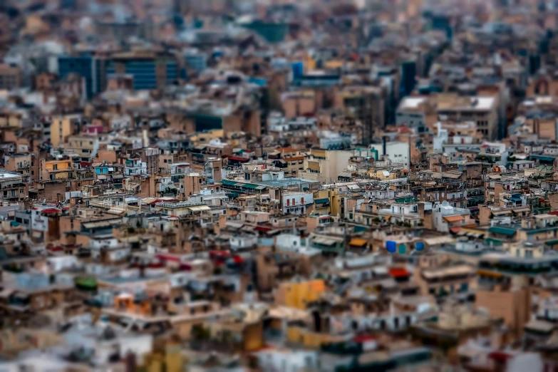 a city filled with lots of tall buildings, a tilt shift photo, by Luis Molinari, pexels contest winner, photorealism, moroccan city, barcelona, very sparse detail, shallow depth of fielf