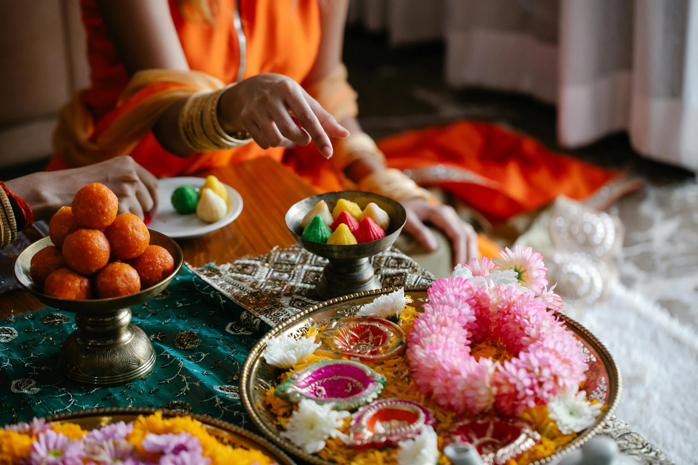 a close up of plates of food on a table, hindu aesthetic, bed of flowers on floor, colourful clothing, praying