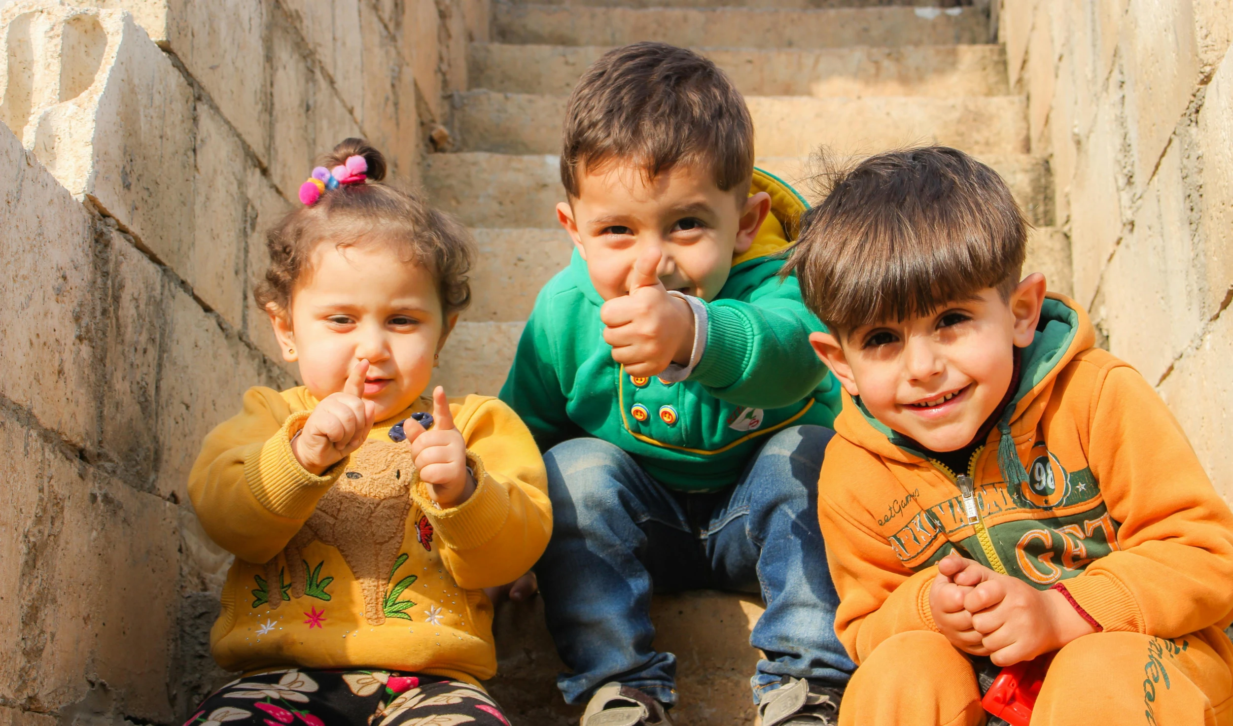 a group of children sitting next to each other, by Arthur Sarkissian, pexels contest winner, thumb up, 2 years old, sam nassour, good face