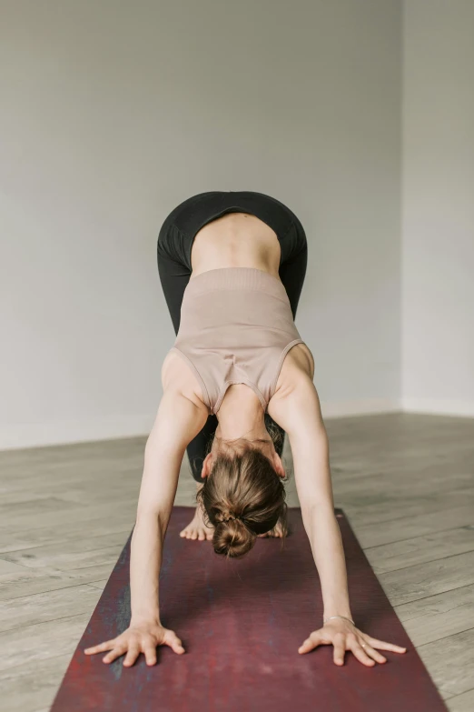 a woman doing a handstand pose on a yoga mat, unsplash, hands behind back, centred, low quality photo, “ full body