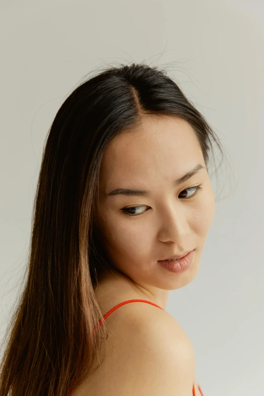 a woman in a red dress posing for a picture, an album cover, inspired by Zhang Shuqi, pexels contest winner, halfbody headshot, ethnicity : japanese, woman's face looking off camera, studio shoot