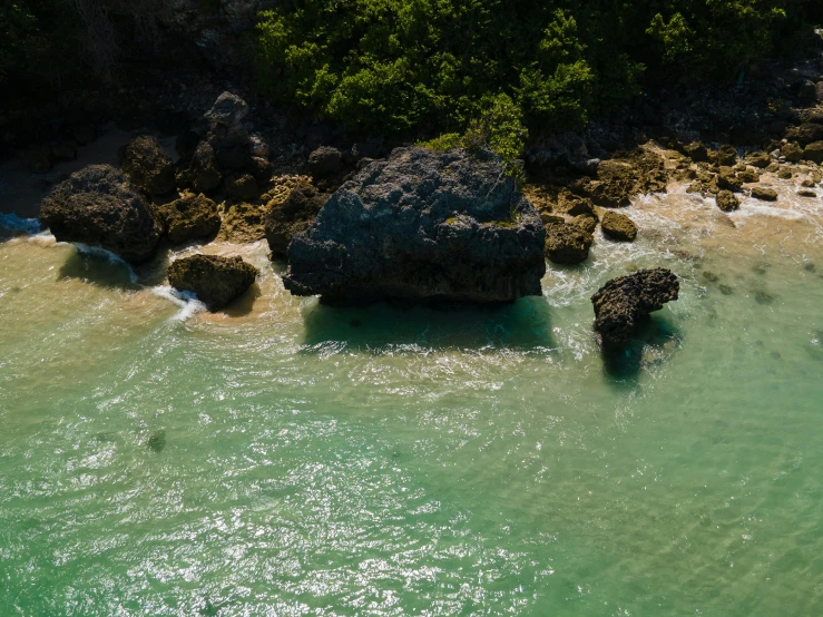 a body of water that has some rocks in it, pexels contest winner, hurufiyya, jamaican vibe, aerial, teaser, rock formations