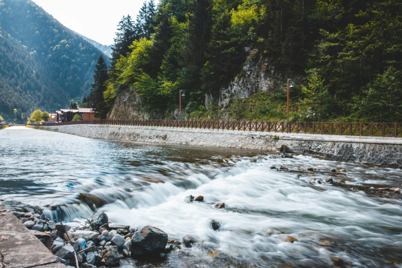 a river running through a lush green forest filled with trees, by Julia Pishtar, pexels contest winner, hurufiyya, turbulent lake, river flowing through a wall, thumbnail, building along a river