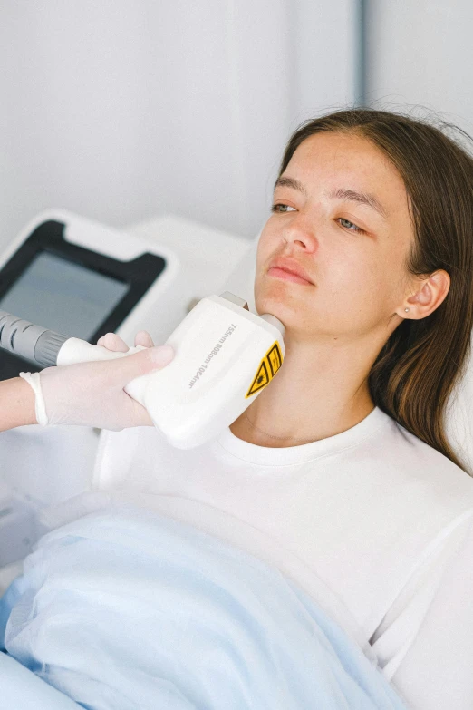 a woman in a white shirt laying in a hospital bed, by Adam Marczyński, trending on pexels, with electric arc device, chiseled jawline, using the degrade technique, model is wearing techtical vest