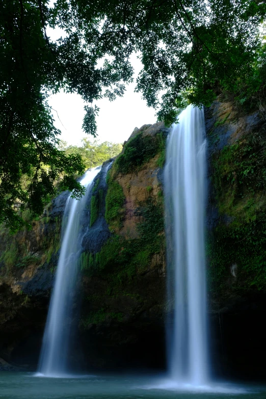 a waterfall in the middle of a lush green forest, sumatraism, ancient ruins and waterfalls, family friendly, 9/11, may)