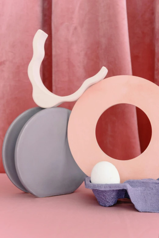 a couple of eggs sitting on top of an egg carton, an abstract sculpture, inspired by Jean Arp, trending on pinterest, violet and pink palette, round-cropped, product display photograph, pink arches