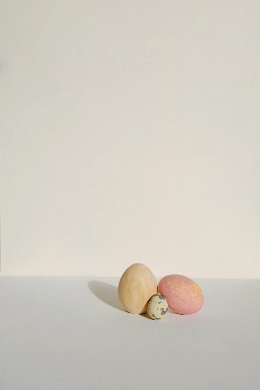 a couple of eggs sitting on top of a table, by Peter Alexander Hay, hyperrealism, rinko kawauchi, muted colors. ue 5, a wooden, covered with pink marzipan