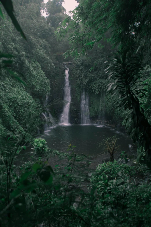 a waterfall in the middle of a lush green forest, an album cover, unsplash contest winner, sumatraism, reunion island, low light, lakes, multiple stories