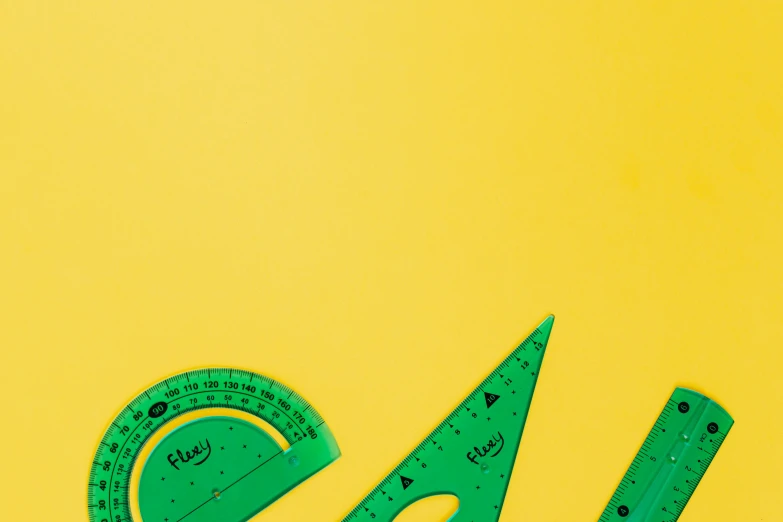 a pair of green rulers sitting on top of a yellow surface, visual art, triangles, arcs, hand, toys