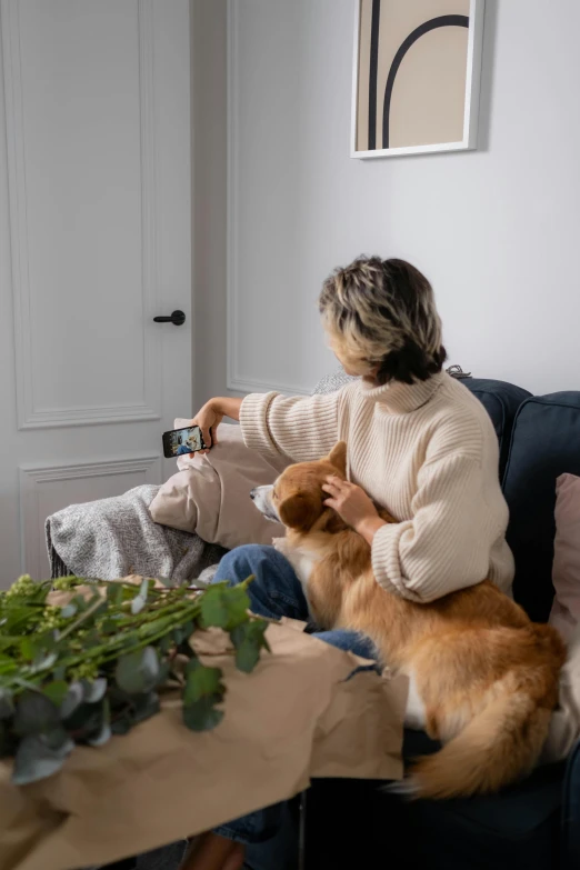 a woman sitting on a couch with a dog, checking her phone, plants, shot with sony alpha, avatar image
