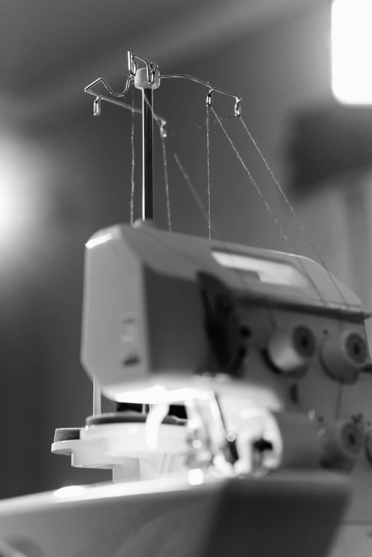 a black and white photo of a sewing machine, by Ai-Mitsu, stopmotion animation, medium format, wires hanging, trending photo