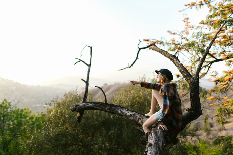 a woman sitting on top of a tree branch, by Jessie Algie, unsplash, mulholland drive, lachlan bailey, looking forward, guide