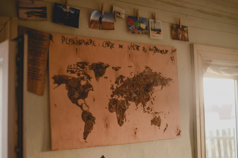 a map of the world hanging on a wall, an album cover, trending on unsplash, environmental art, wood burn, screenshot from a movie, copper, whiteboard