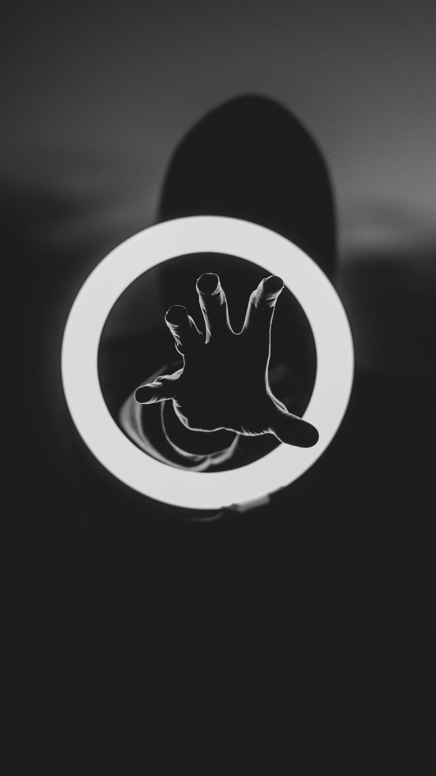 a black and white photo of a person's hand, unsplash, neon outline, circular face, claw, black mirror