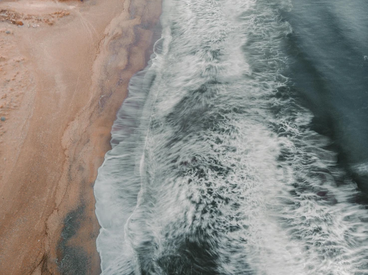 a large body of water next to a sandy beach, by Daniel Lieske, pexels contest winner, swirling fluid, trending on vsco, oceanside, a high angle shot