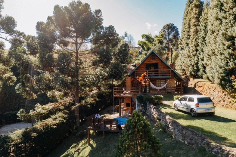 a car is parked in front of a house, by Daniel Lieske, unsplash, andes mountain forest, sao paulo, pine treehouse, sun drenched