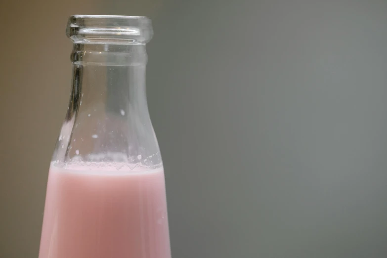 a bottle of milk sitting on top of a table, light pink, thumbnail, filling the frame, light skin