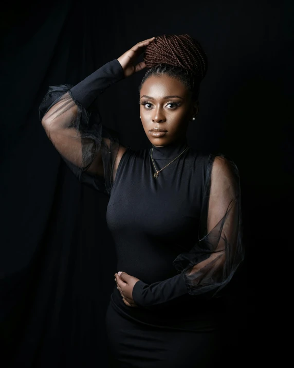 a woman in a black dress posing for a picture, by Lily Delissa Joseph, pexels contest winner, afrofuturism, black turtle neck shirt, black backdrop, square, looking serious