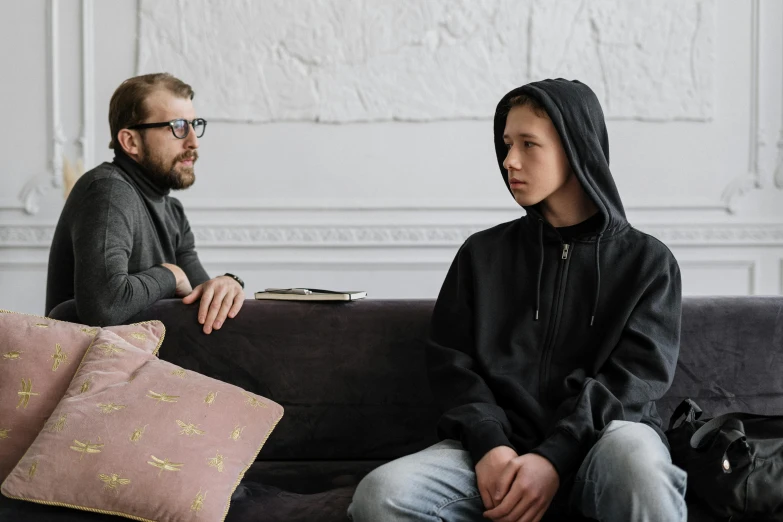 a man and a woman sitting on a couch, trending on pexels, visual art, wearing jeans and a black hoodie, young boy, mental illness, asian man