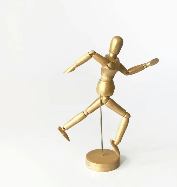 a wooden mannequin standing on a wooden base, kinetic art, gold metal, running pose, fully posable, 2019 trending photo