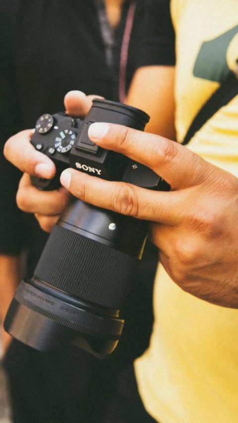 a close up of a person holding a camera, sony a7z, low quality photo, sony 175mm”