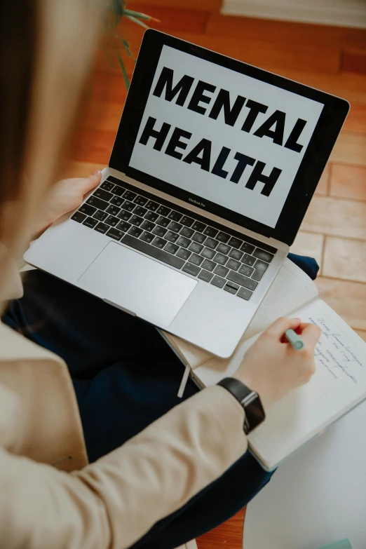 a woman sitting in front of a laptop with mental health written on the screen, trending on pexels, zoomed in, schools, medical book, brown