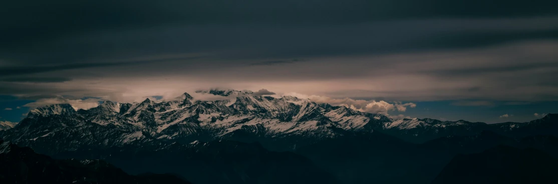 a mountain covered in snow under a cloudy sky, pexels contest winner, romanticism, ominous evening, brown, dark, music video