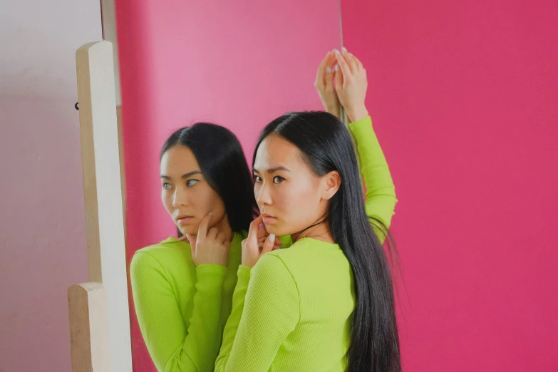 a couple of women standing in front of a mirror, inspired by Ren Hang, trending on pexels, magic realism, lime green, young asian girl, waist reaching ponytail, with long hair