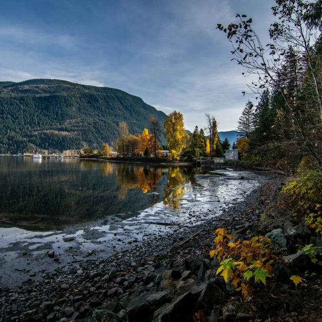 a body of water with a mountain in the background, by Chris Rallis, pexels contest winner, visual art, autumn lights, shoreline, fjord, black fir